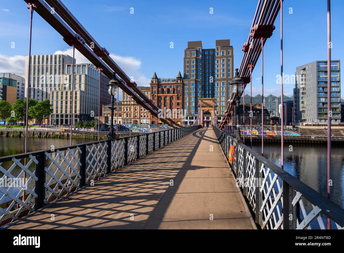 City skyline of Glasgow from South Portland Street Suspension Bridge in Glasgow, Scotland, United Kingdom. Footbridge from 1853 across the River Clyde Stock Photo