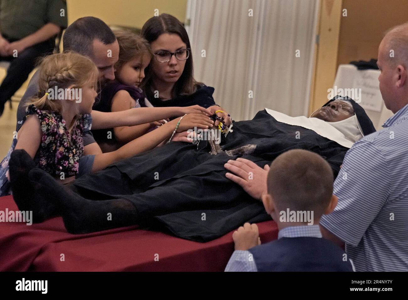 People pray over the body of Sister Wilhelmina Lancaster at the