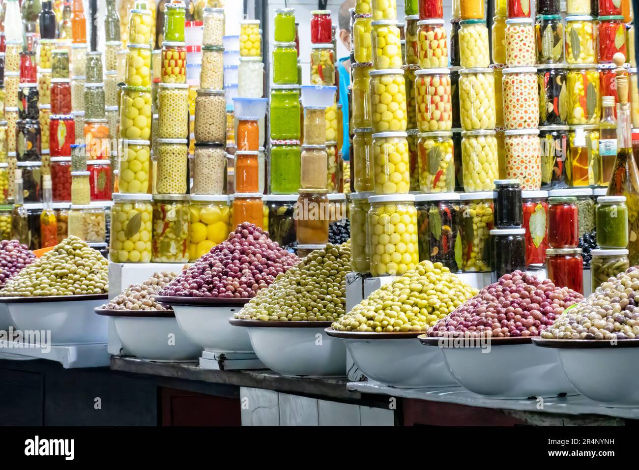 Fresh assorted olives and olives in jars for sale in souks stalls located in the central souk area, Marrakesh, Morocco. an impressive tempting display Stock Photo