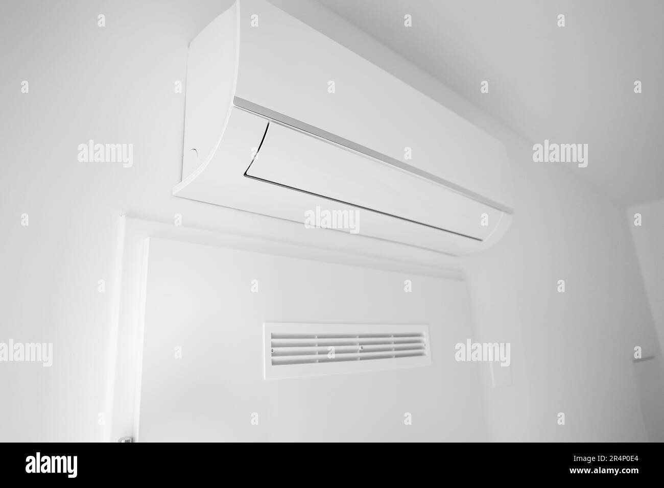 Modern air conditioner hanging on light wall in room Stock Photo - Alamy