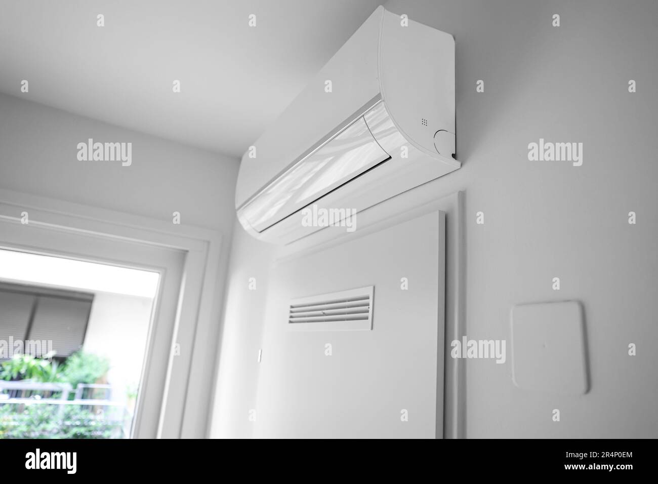 Modern air conditioner hanging on light wall in room Stock Photo Alamy