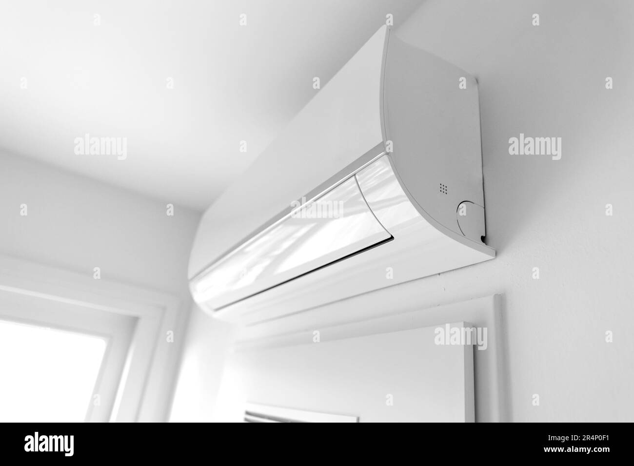 Modern air conditioner hanging on light wall in room Stock Photo Alamy