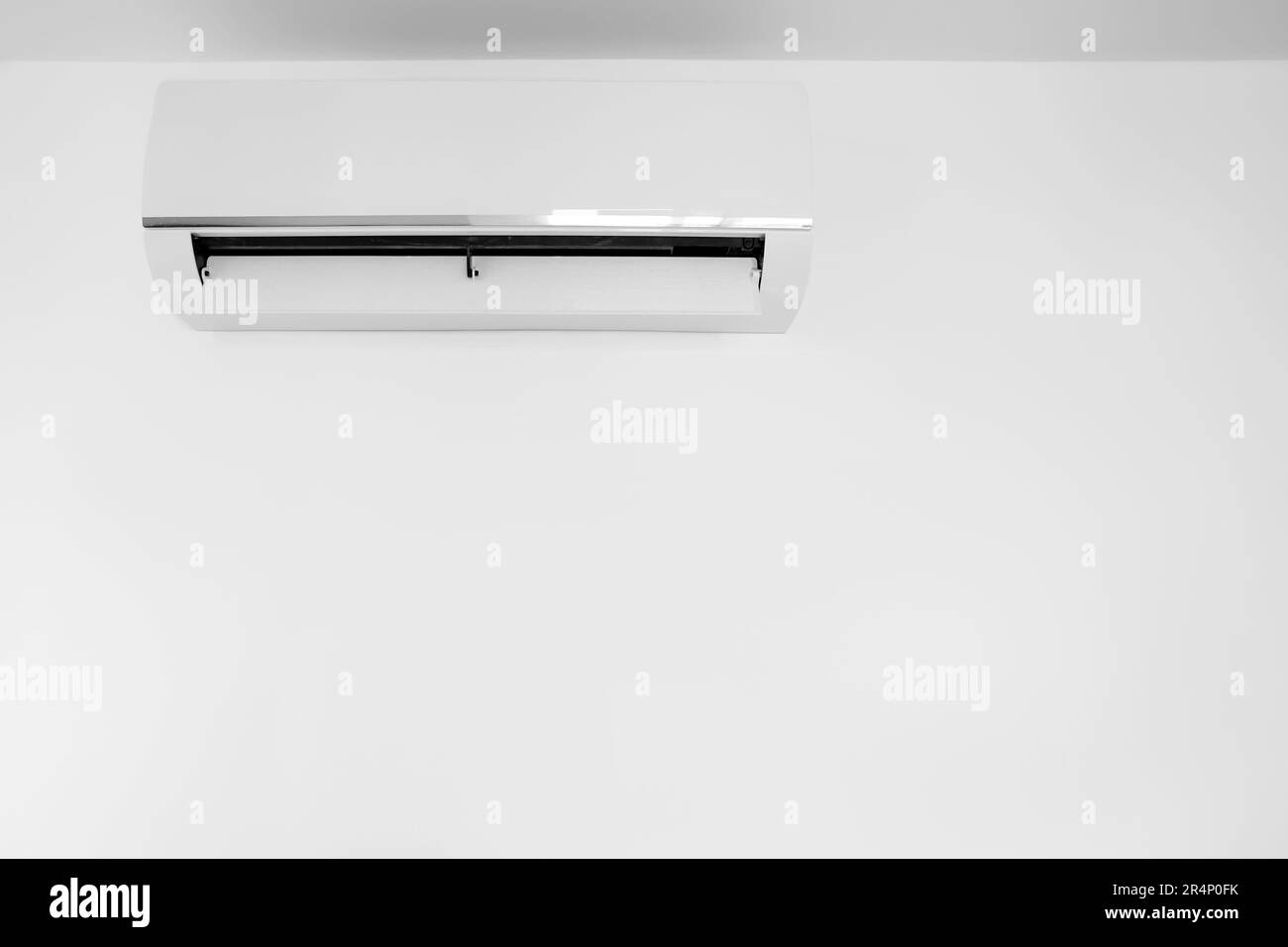 Modern air conditioner hanging on light wall in room Stock Photo - Alamy