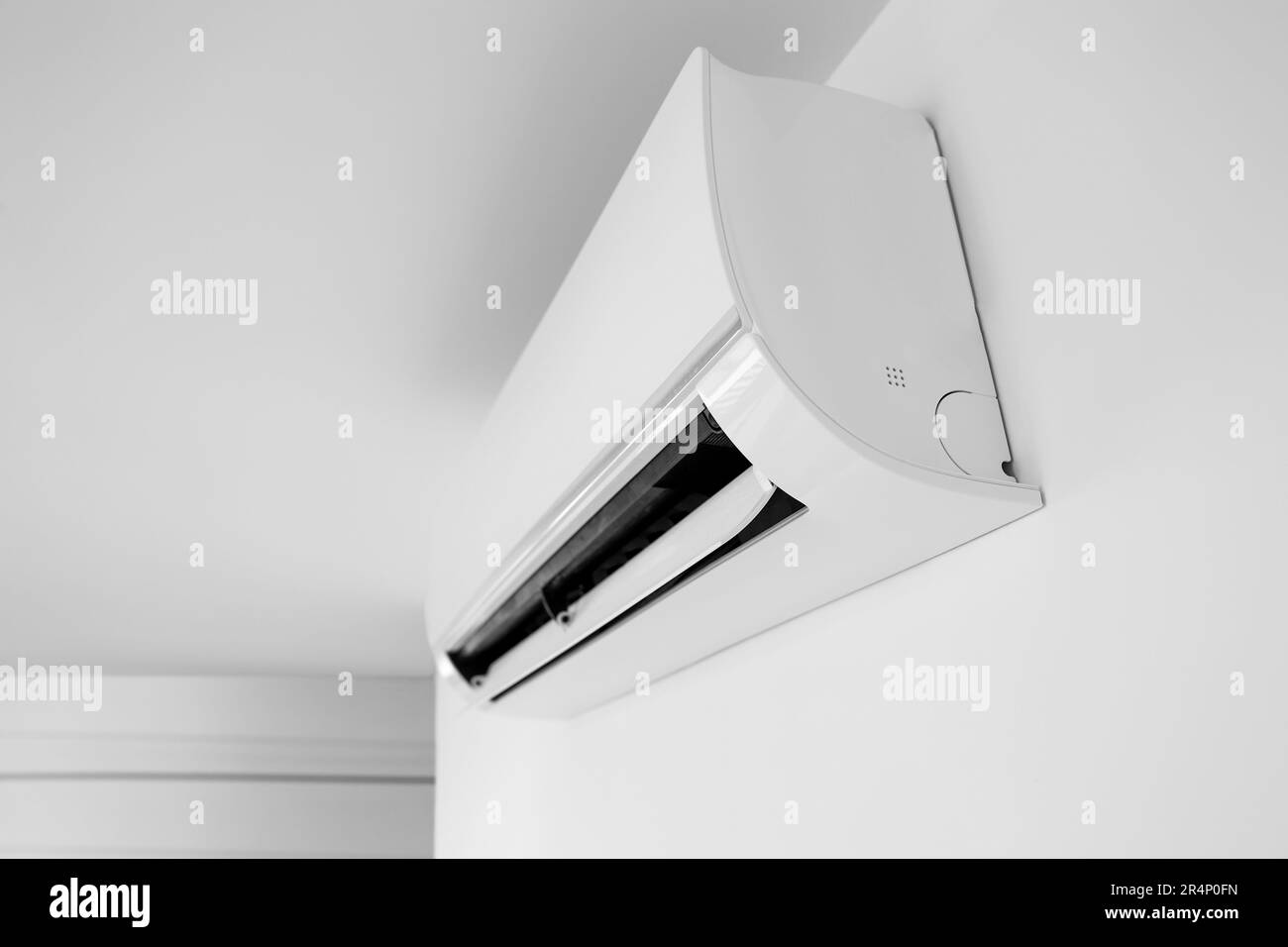 Modern air conditioner hanging on light wall in room Stock Photo - Alamy