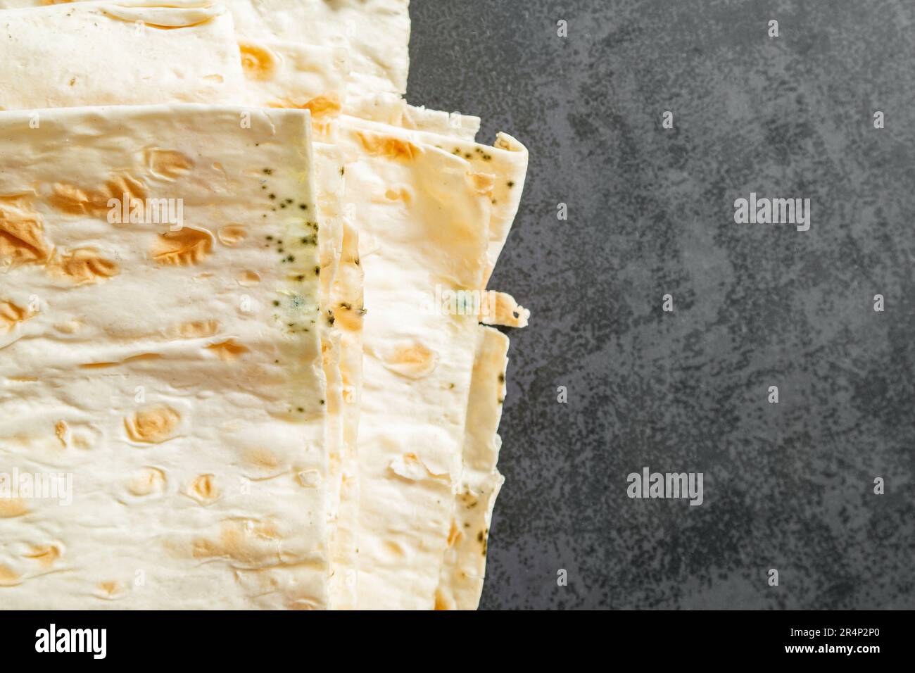 Spoiled pita, moldy. Mildew on the bread. Gray background. copy space Stock Photo