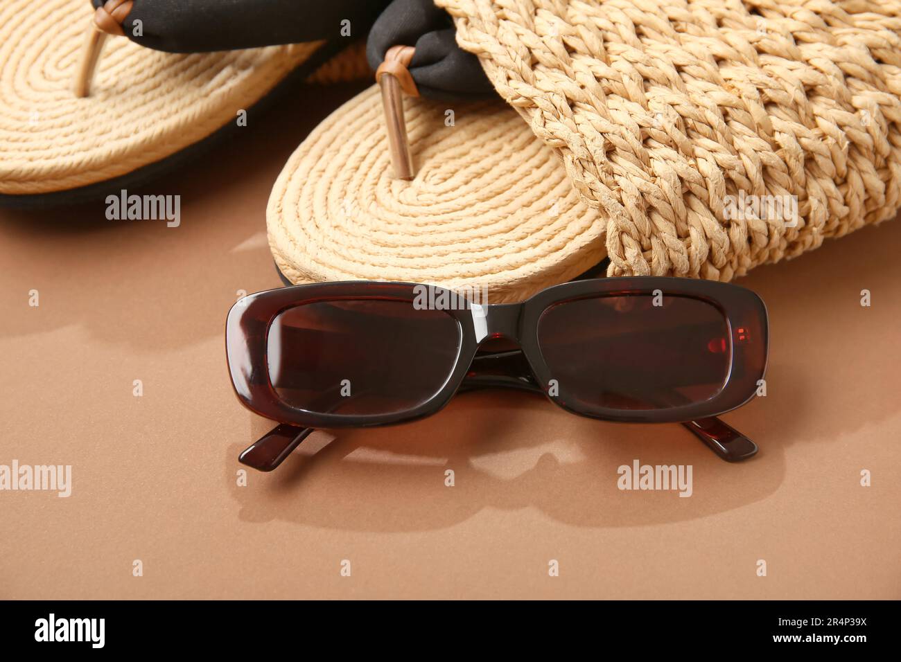 Stylish sunglasses with bag and flip flops on brown background Stock ...