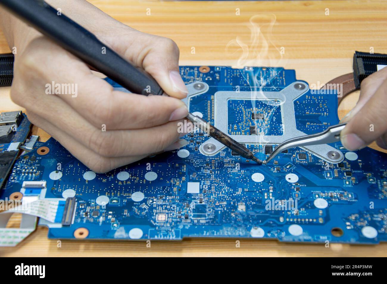 Motherboard repair. Motherboard, solder parts, male, closeup Stock