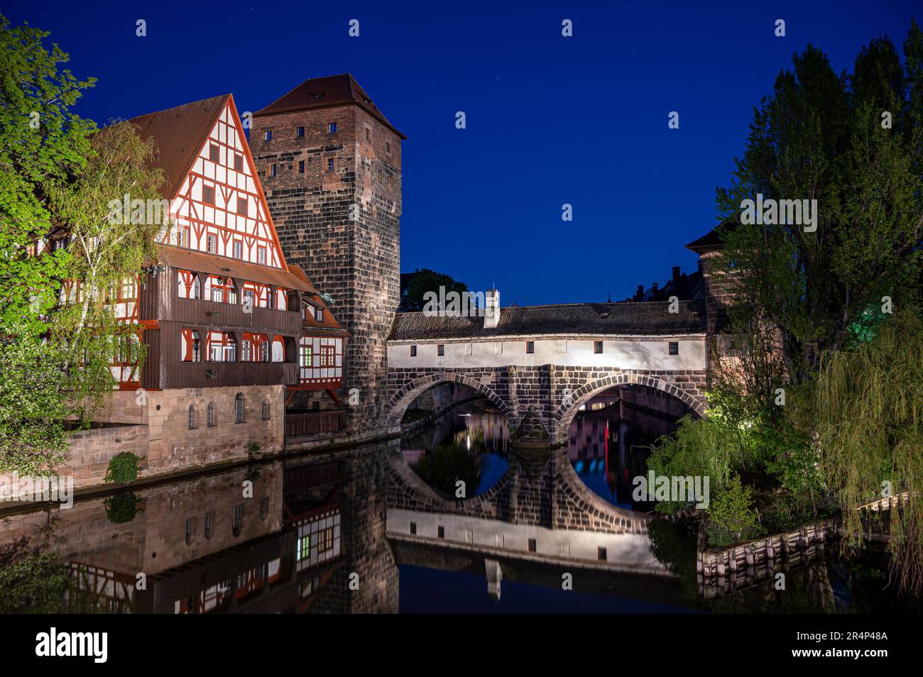Old medieval bridge at night over Pegnitz river in Nuremberg, Germany. Hangman's Bridge. Stock Photo