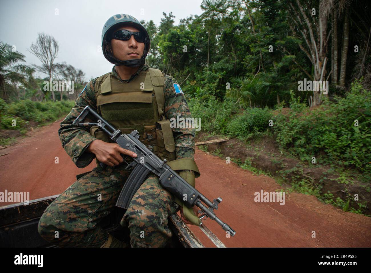 A Guatemalan army peacekeeper rides on the back of a truck, armed with a Galil assault rifle, Democratic republic of Congo Stock Photo