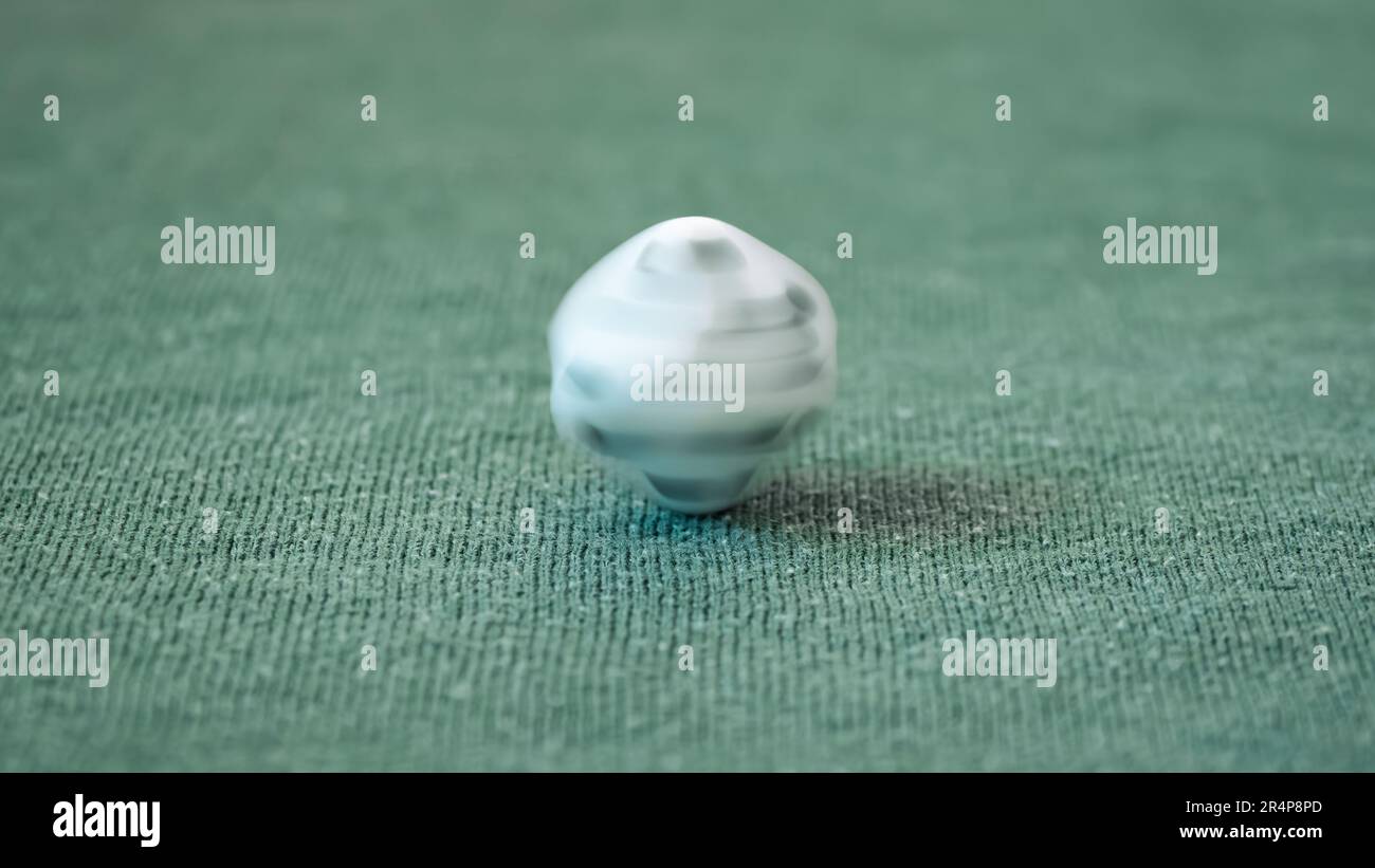 single white game dice spinning in movement on green background as success, chance, choice, decision, luck, lifestyle, balance, fear, greed concept Stock Photo