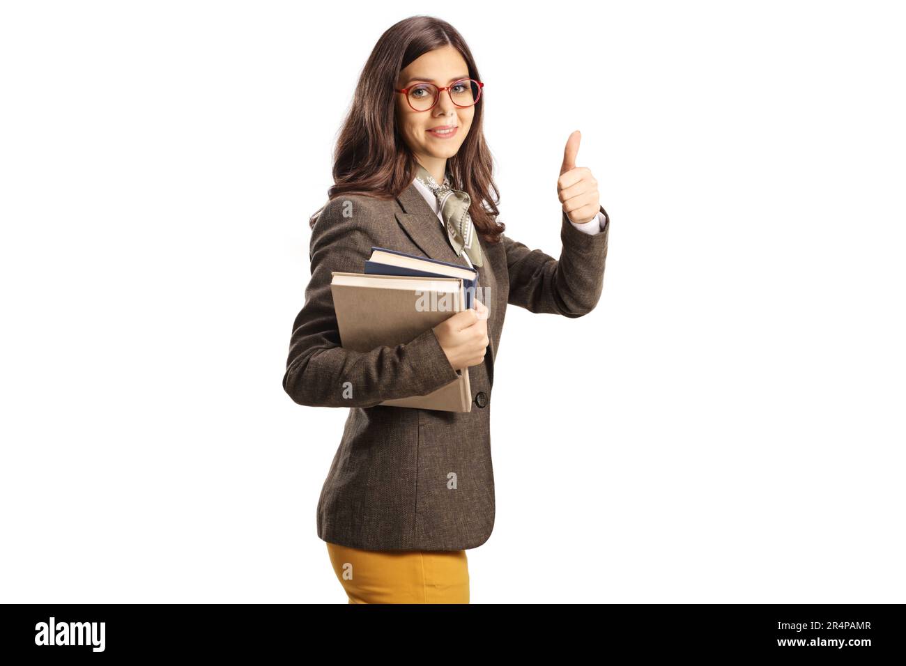 Young female with glasses holding books and gesturing thumbs up ...