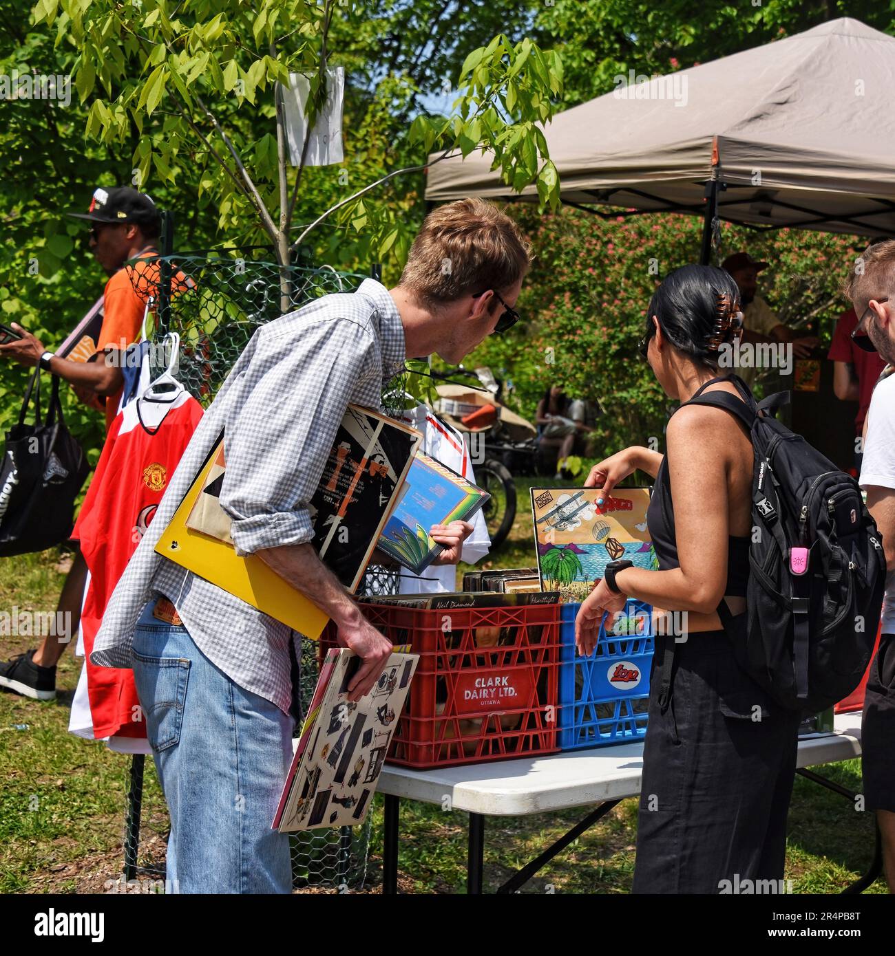 Ottawa, Canada - May 27, 2023: People browse collection of albums the annual Glebe neighborhood garage sale which takes place for several blocks in th Stock Photo
