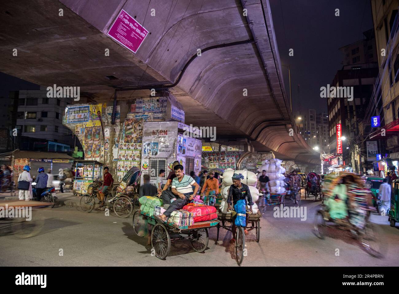 Cycle Rickshaw traffic under a flyover in Old Town Dhaka, Bangladesh Stock Photo
