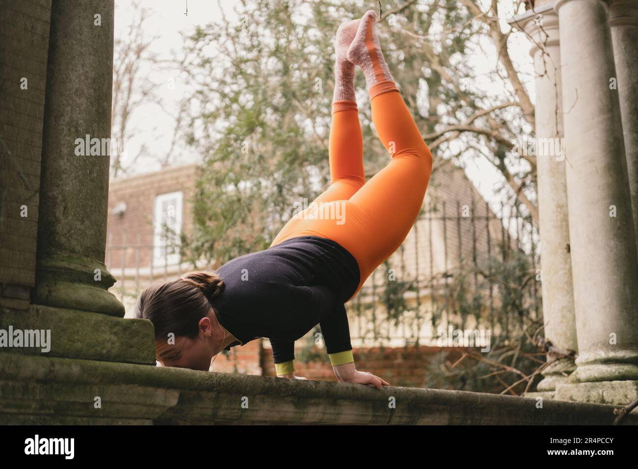 woman-new-yoga-teacher-doing-a-peacock-pose-on-a-classic-stone