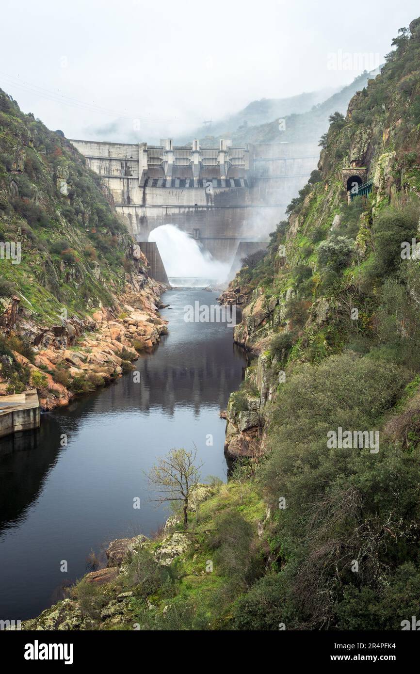 View of the Tua mouth hydroelectric dam in Portugal discharging water on a cloudy autumn day. Stock Photo