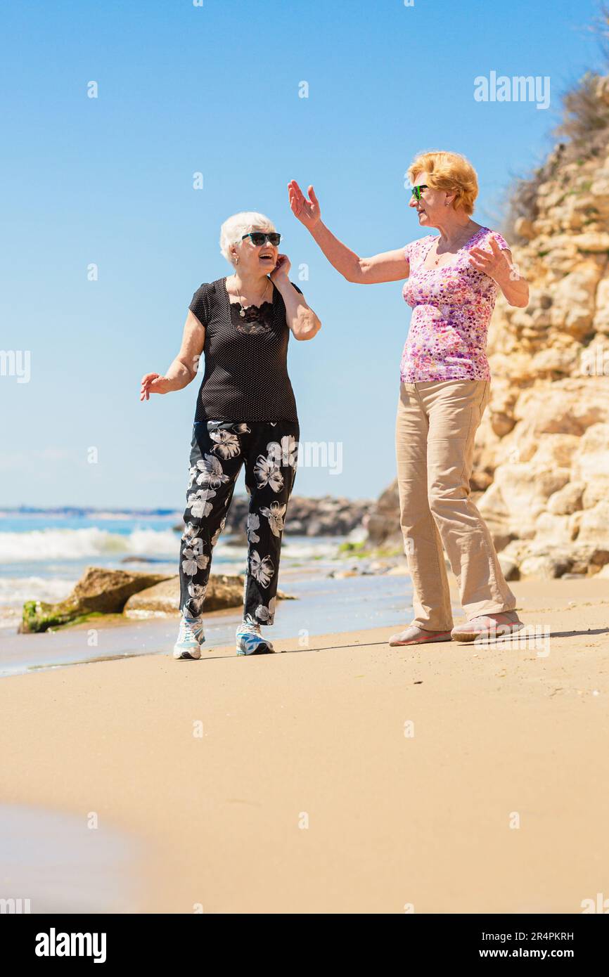 Two mature women walking along hi-res stock photography and images - Alamy