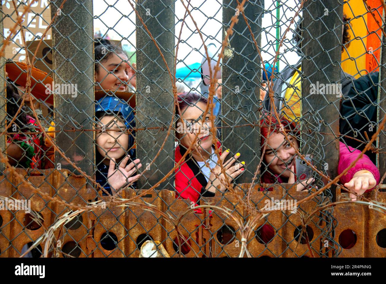 Women in Tijuana Mexico look through the razor wire at the US Mexico border at Border Field Park near San Diego Stock Photo Alamy
