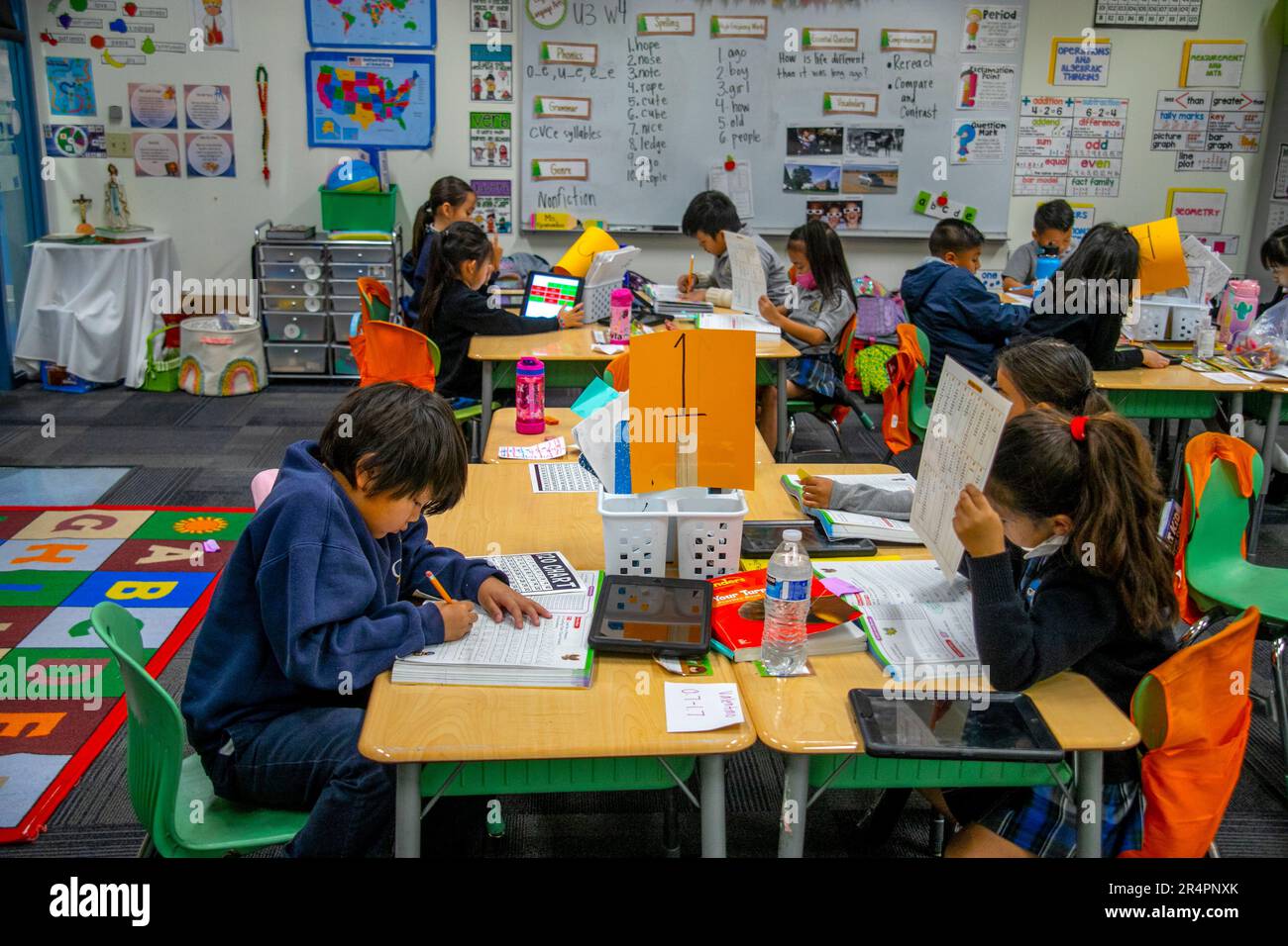 Multiracial first graders work at their desks at a California Catholic