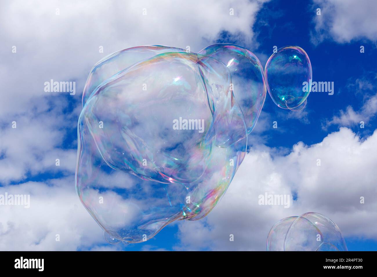 Soap bubbles against a blue sky and puffy white clouds Stock Photo