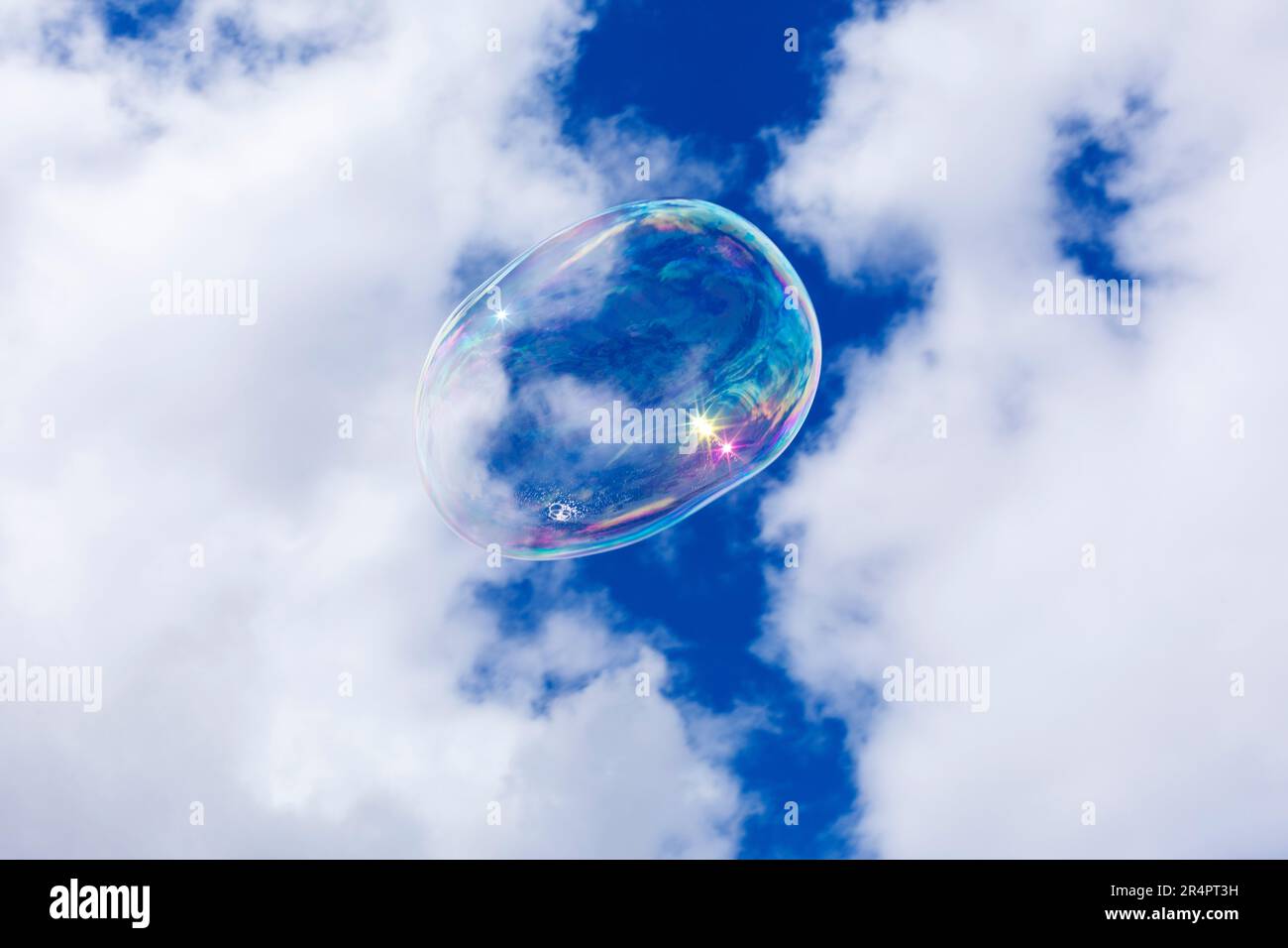 Soap bubbles against a blue sky and puffy white clouds Stock Photo
