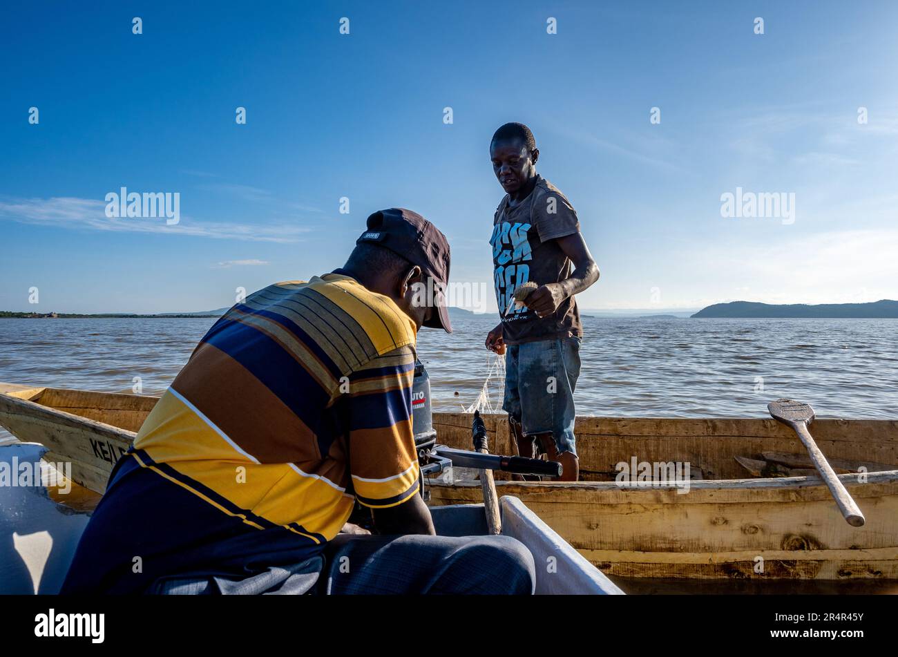 Two men fishing in a small boat on the Lake Baringo. Kenya, Africa