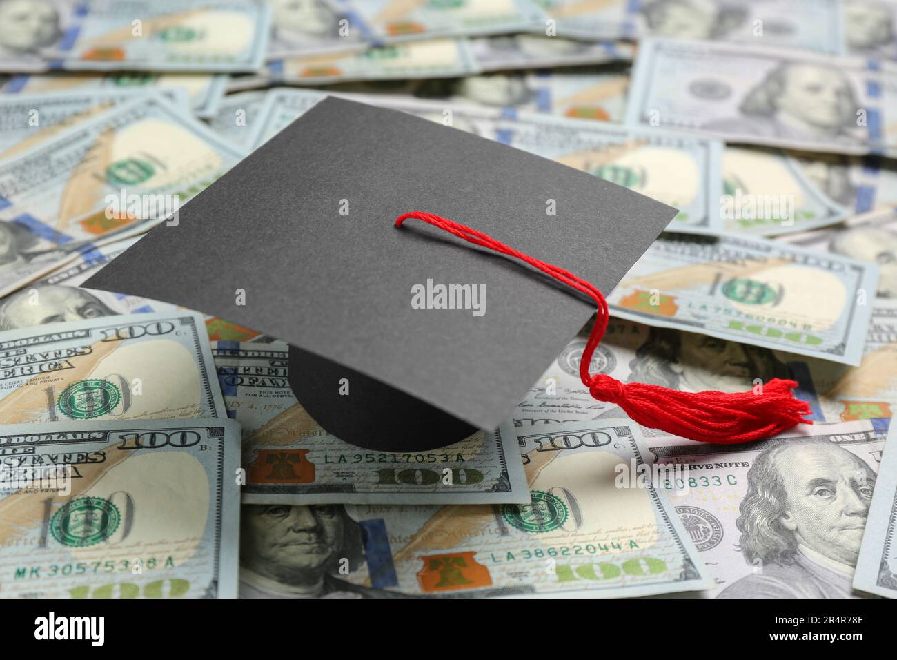 Scholarship concept. Graduation cap on banknotes, closeup Stock Photo