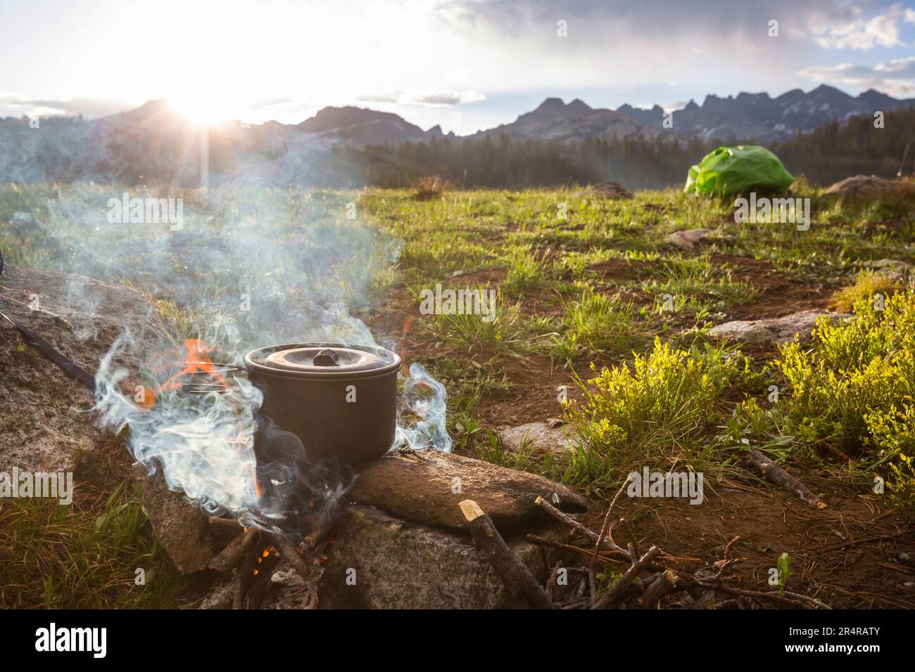 Touristic kettle on fire of burning campfire in camping in the hike