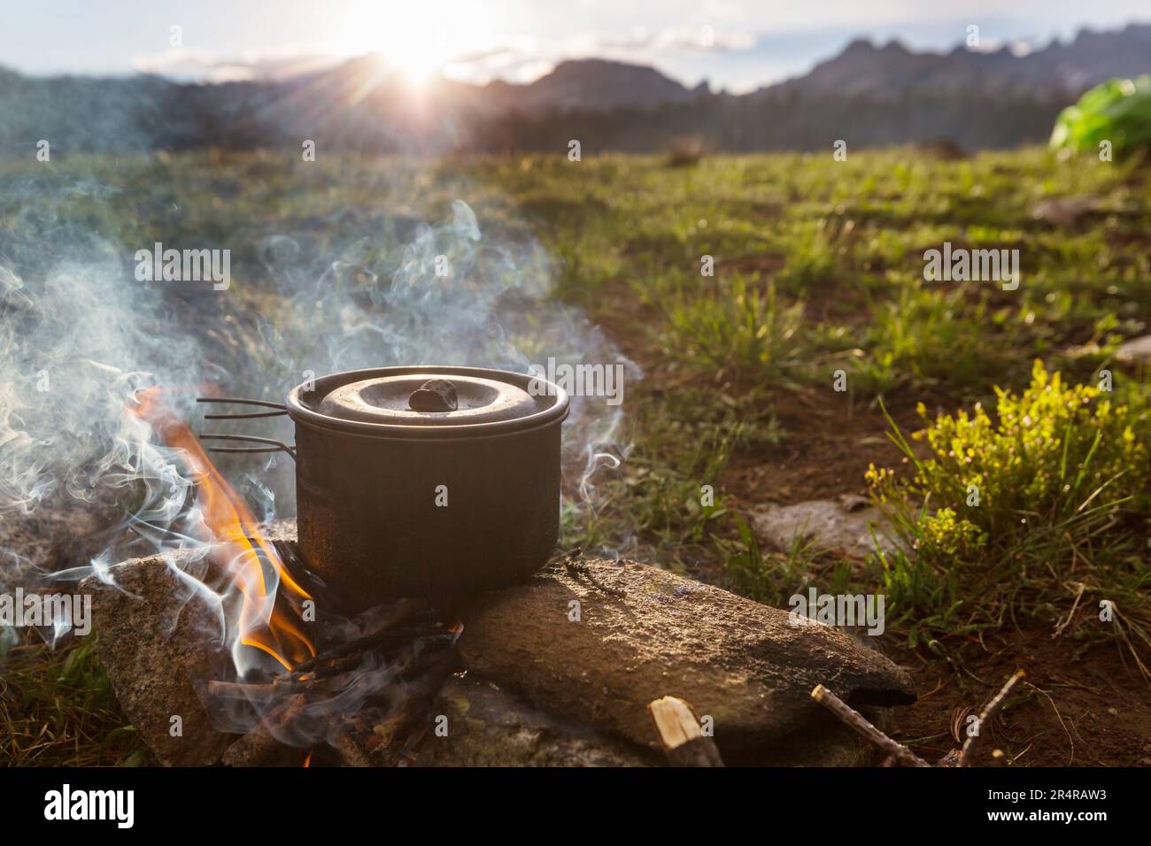 Touristic kettle on fire of burning campfire in camping in the hike