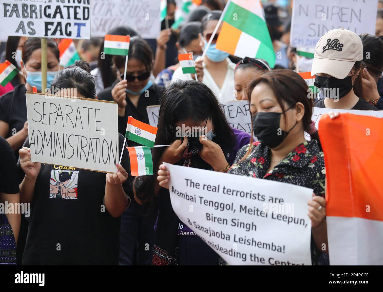 People belonging to Manipur Kuki tribe hold Indian flags and