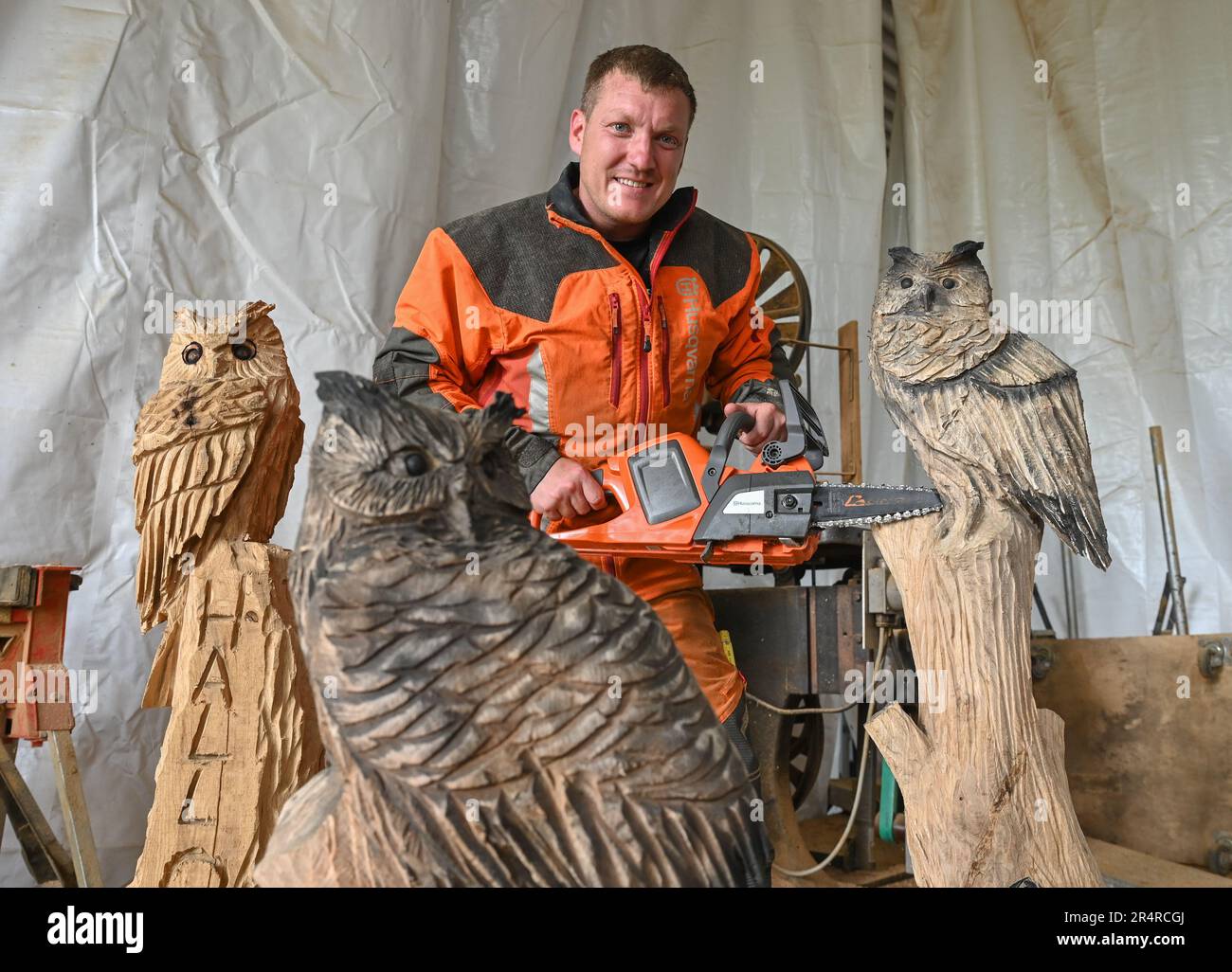 Heinersdorf, Germany. 23rd May, 2023. Christian Mücke, chainsaw artist,  works on an owl made of wood in his workshop. Speedcarving is the name  given to chainsaw art, in which sculptures are created, image size:1300x1026