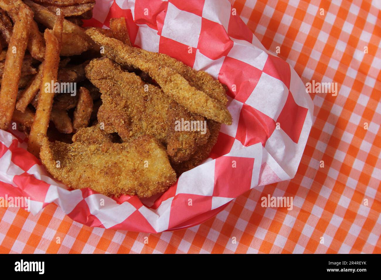 Fried Catfish Basket With French Fries in Rustic Cafe on Checkered