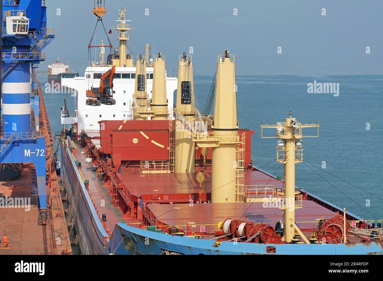 YANTAI, CHINA - MAY 29, 2023 - Cranes load construction machinery exported to Mexico onto the 'Yantai Mexico' general cargo liner at the port of Yanta Stock Photo