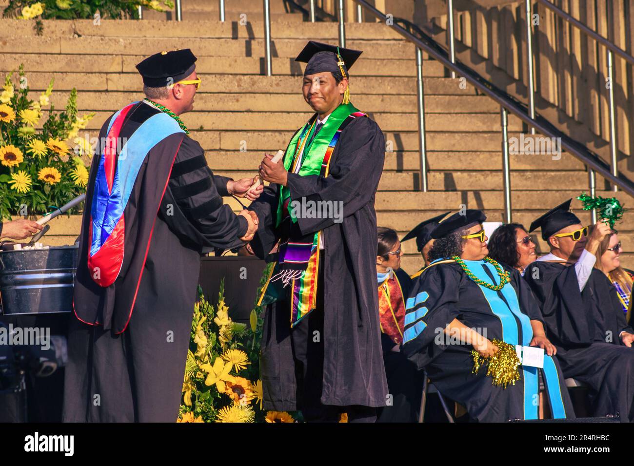 The image captures a defining moment as Crafton Hills College President, Dr. Kevin Horan, hands Gio Skelton his diploma and associate of arts degree Stock Photo