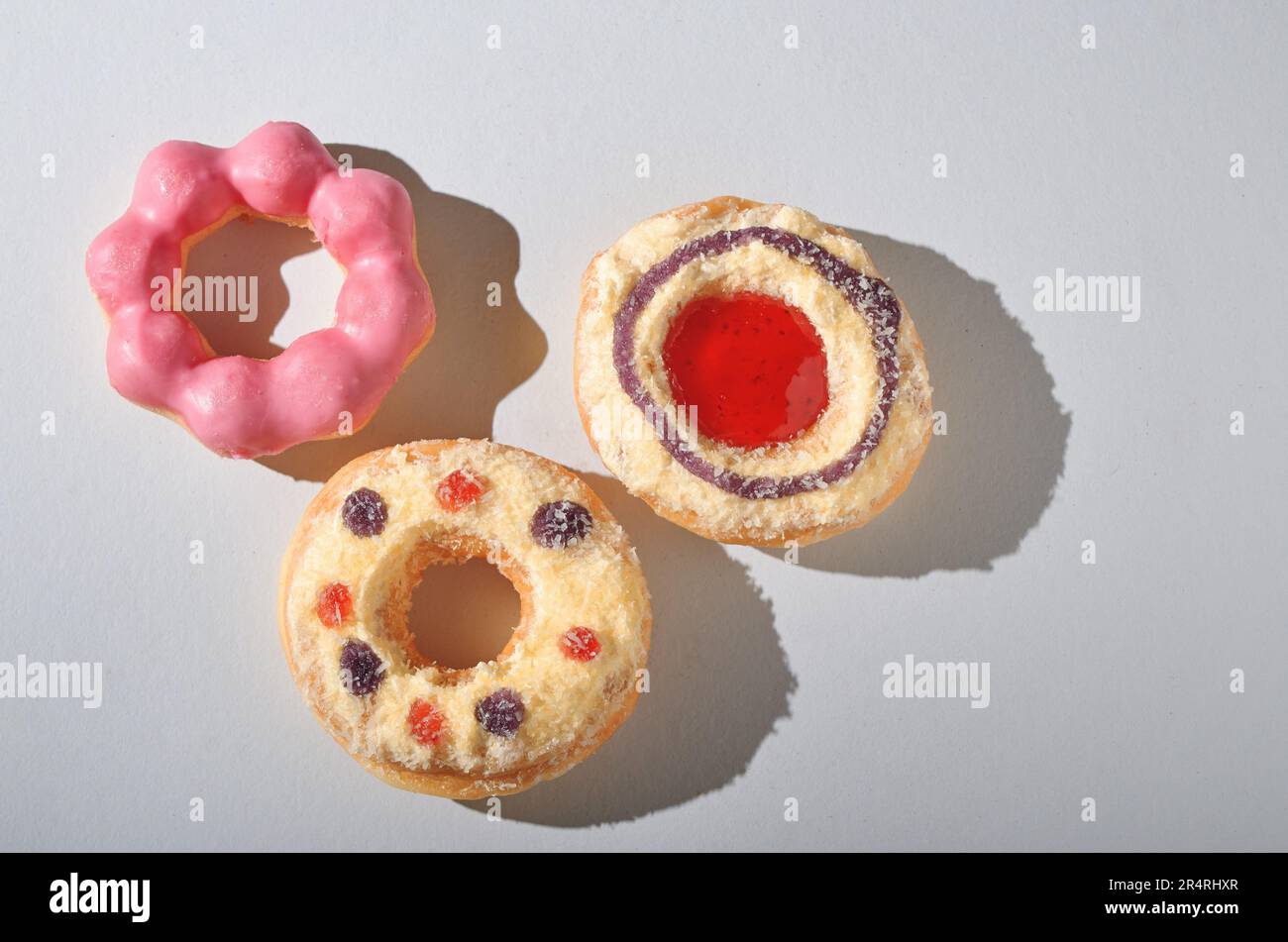 Donuts with icing and sprinkles on white background Stock Photo - Alamy
