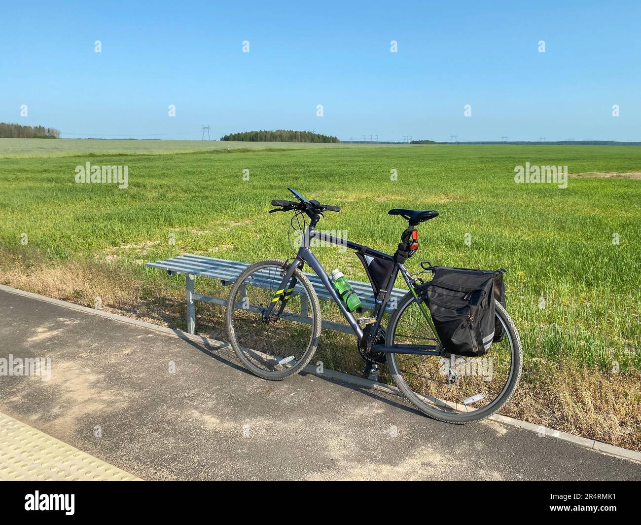 Bicycle with a bike frame bag and pannier bags on the background of an open space of the countryside. Concept of travel by bike, active and sporty lif Stock Photo
