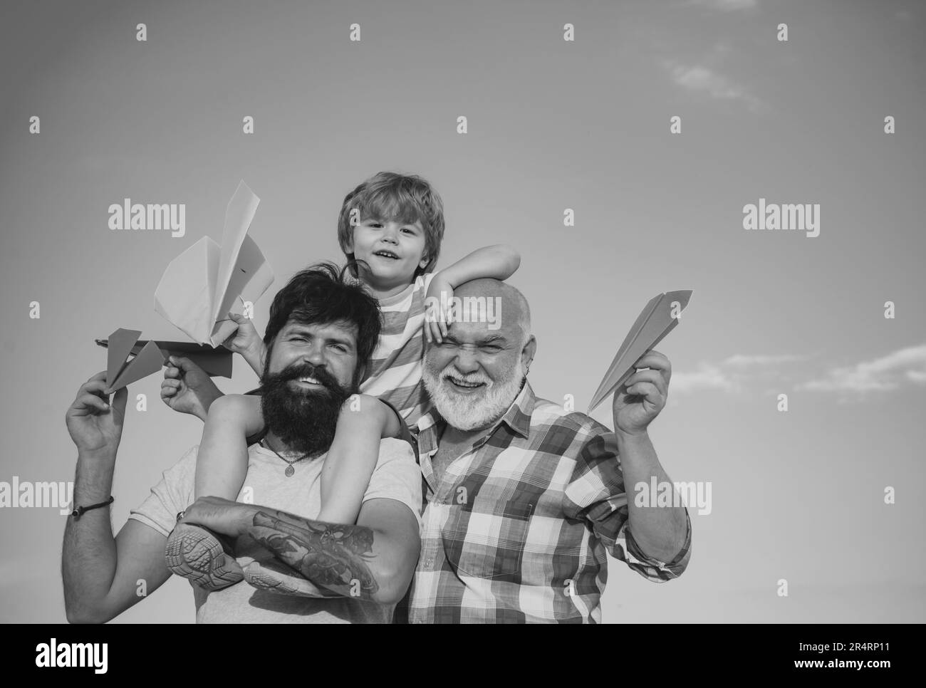 Cute child hugging his father and grandfather. Happy smiling boy on ...