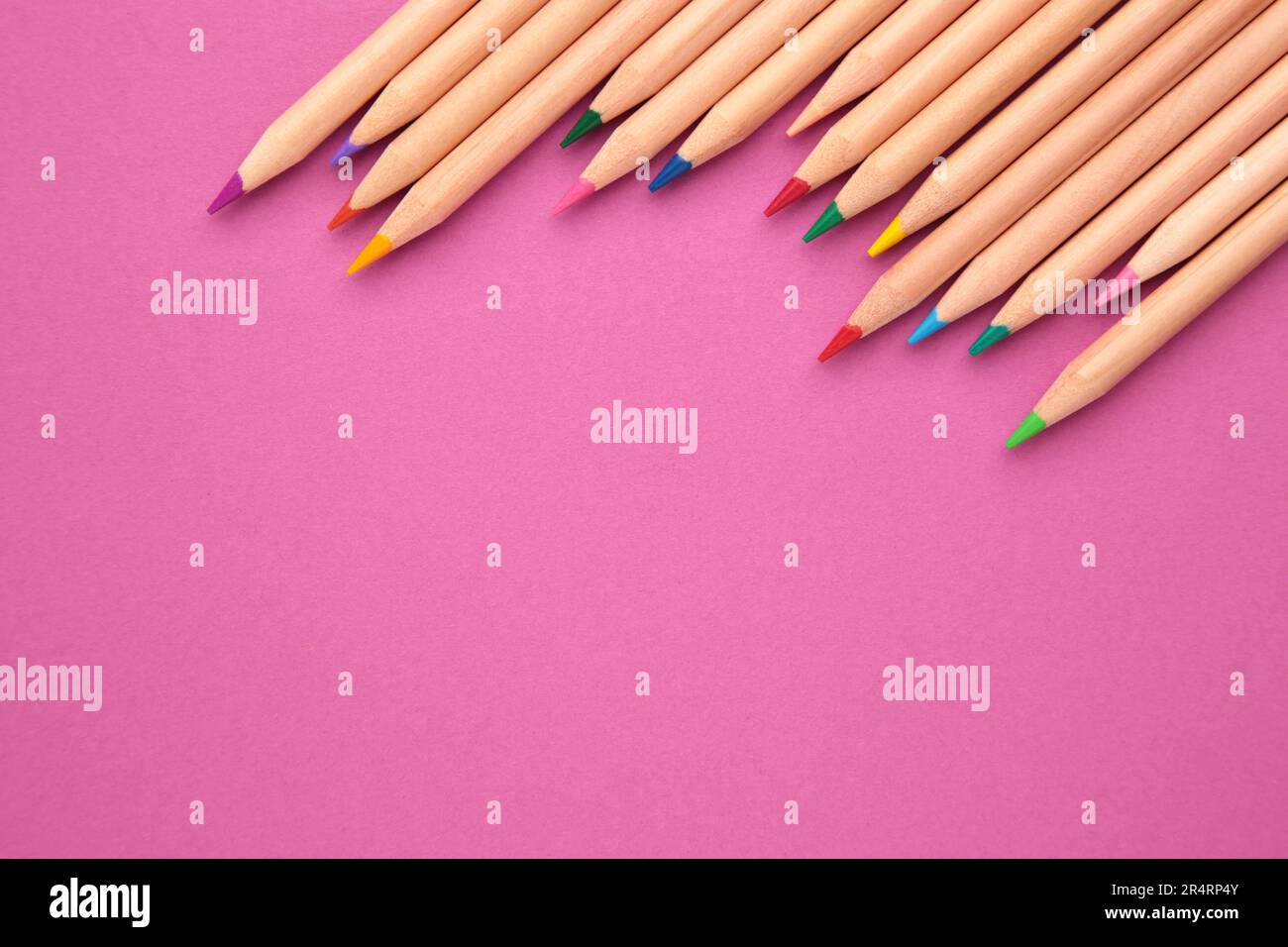 Colored pencils on the pink background. Top view Stock Photo - Alamy