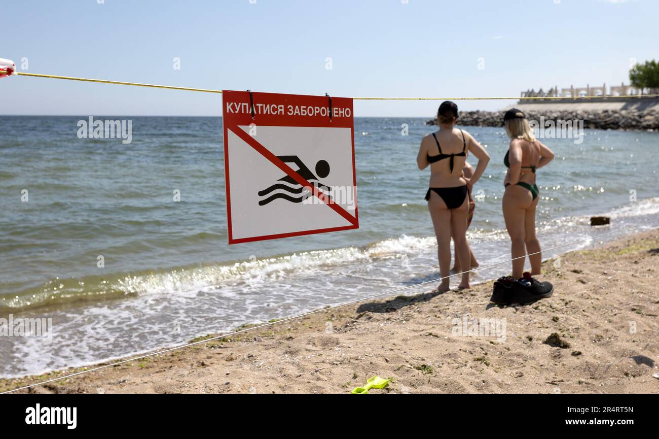 bright red 'No Swimming' sign on city's sea sandy beach in Odessa during Russia's attack on Ukraine. Swimming is prohibited! Approaching the water is Stock Photo