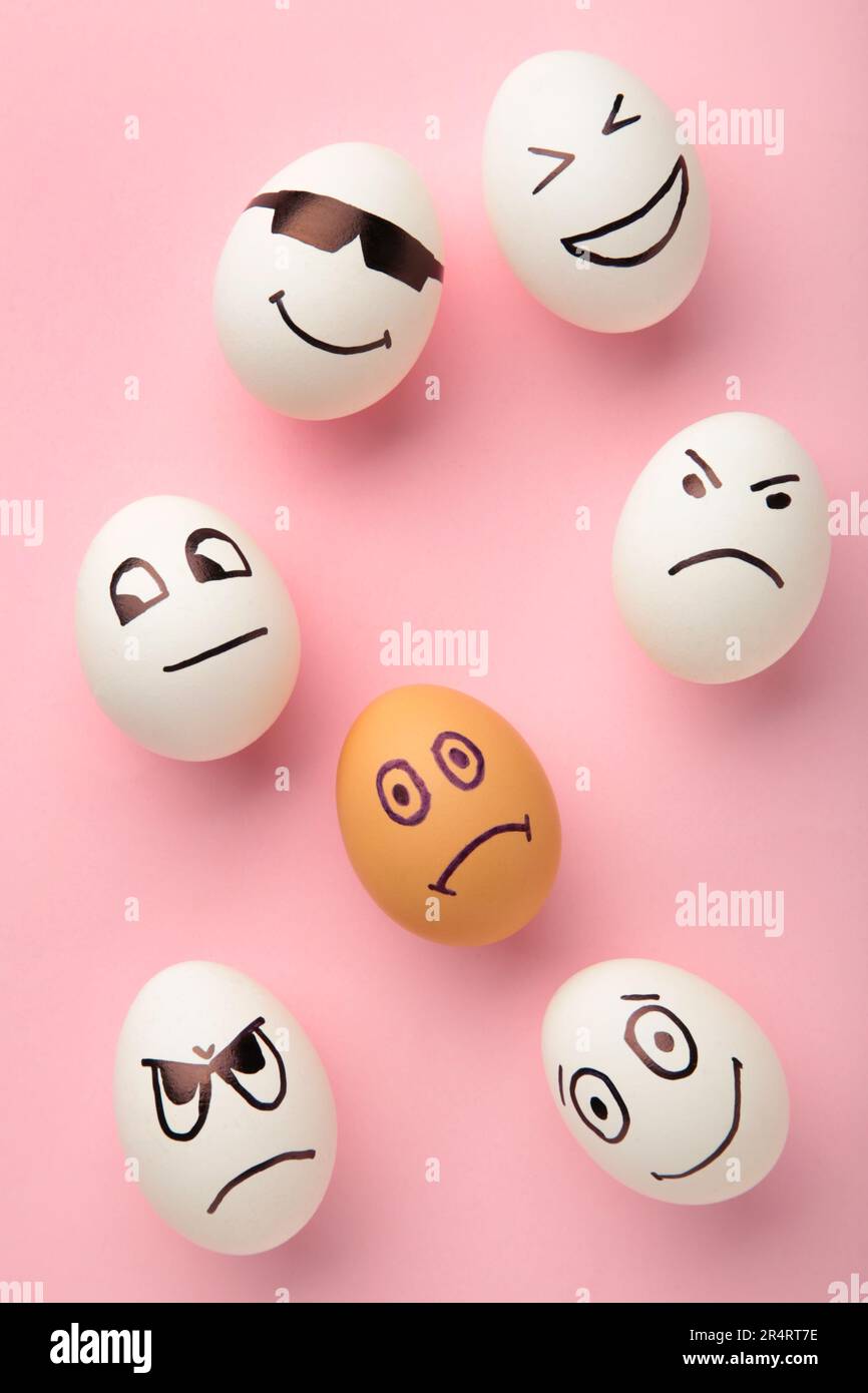 Eggs with different emotions on his face. Easter composition with copy space on pink background. Stop racism. Top view Stock Photo