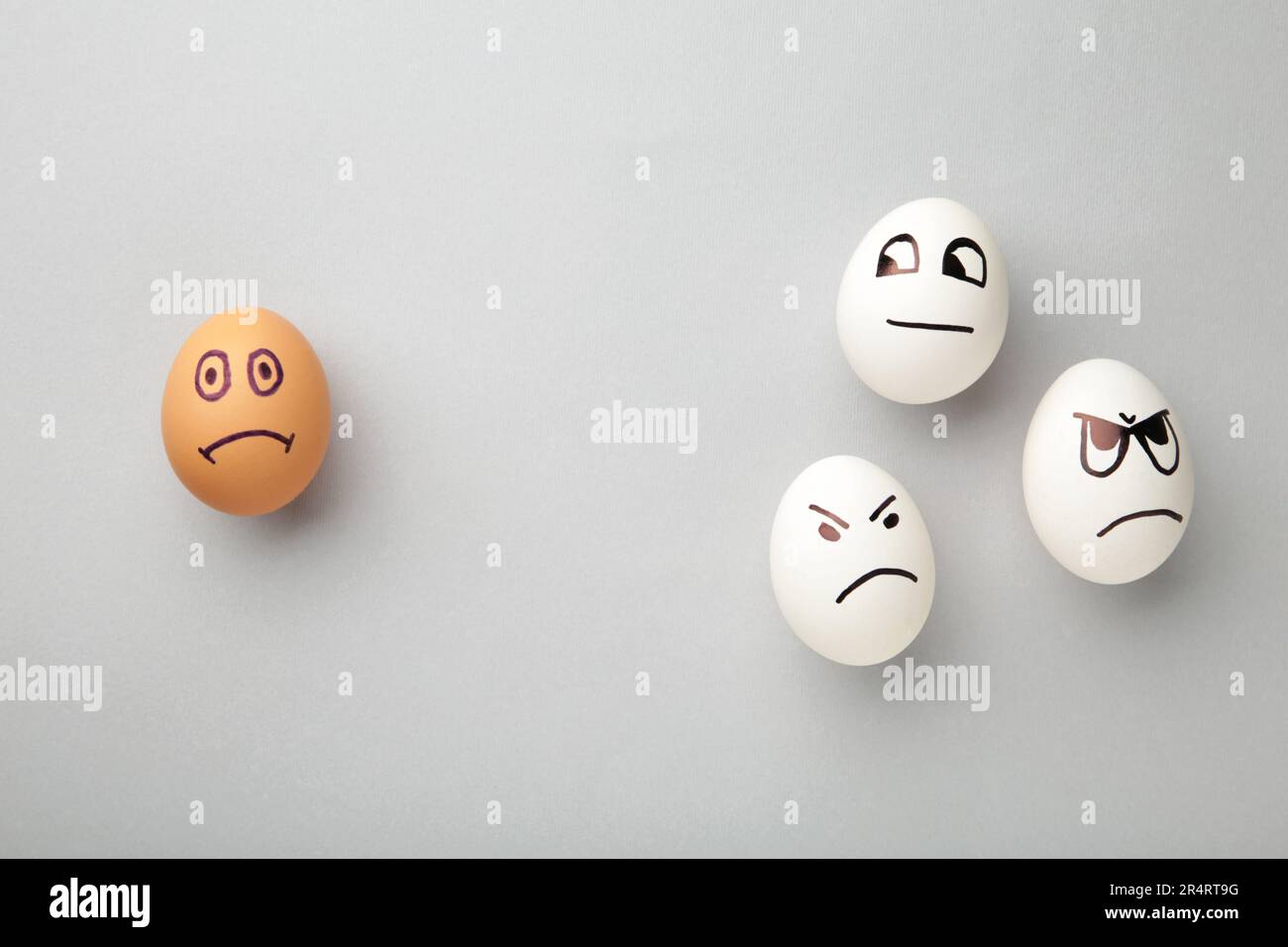 Eggs with different emotions on his face. Easter composition with copy space on grey background. Stop racism. Top view Stock Photo