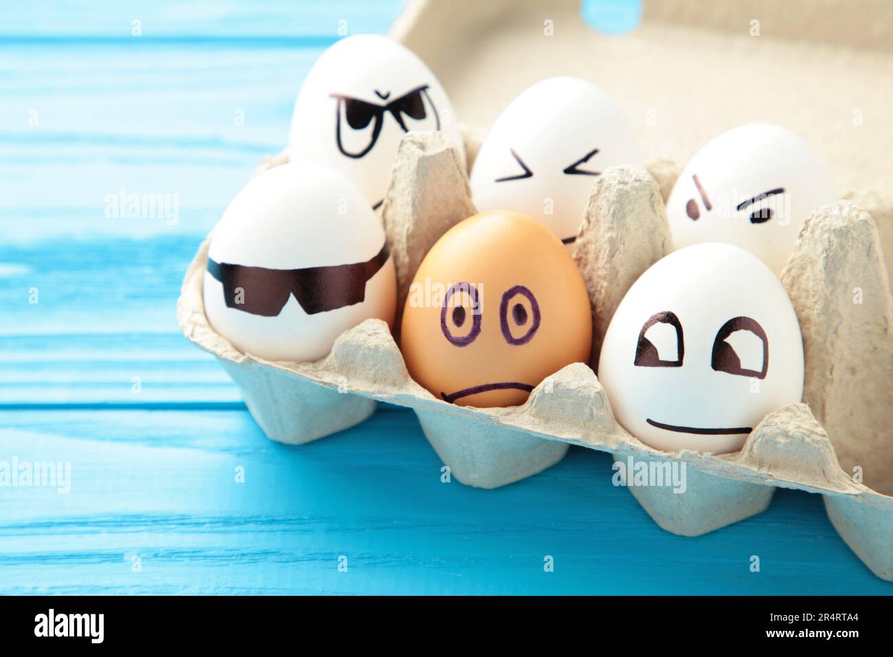 Eggs with different emotions on his face. Easter composition with copy space on blue background. Stop racism. Top view Stock Photo