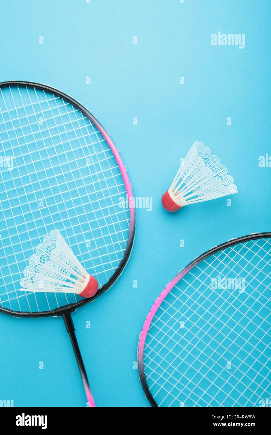 Shuttlecocks and badminton rackets on blue background. Top view. Stock Photo