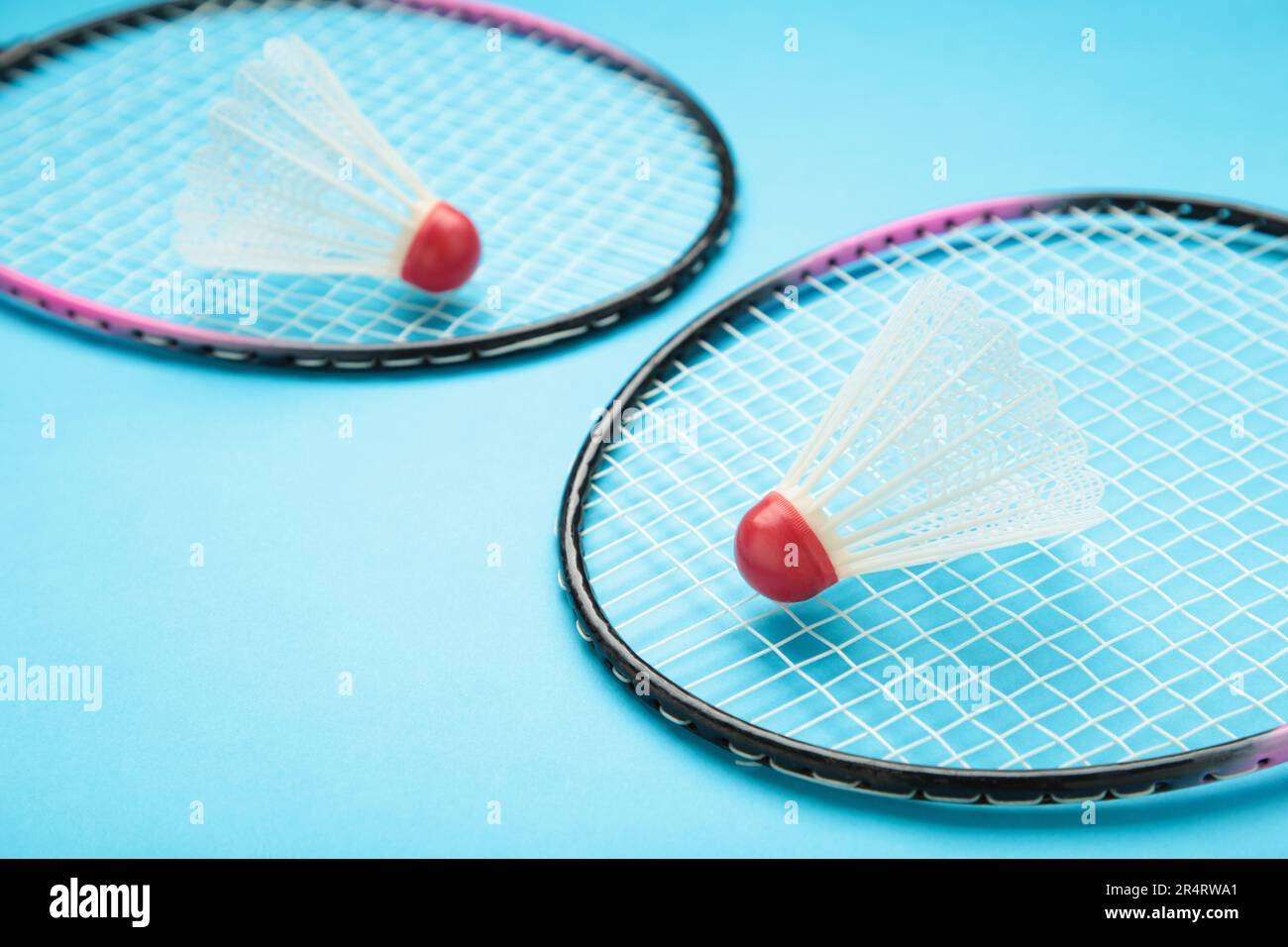 Shuttlecocks and badminton rackets on blue background. Top view. Stock Photo