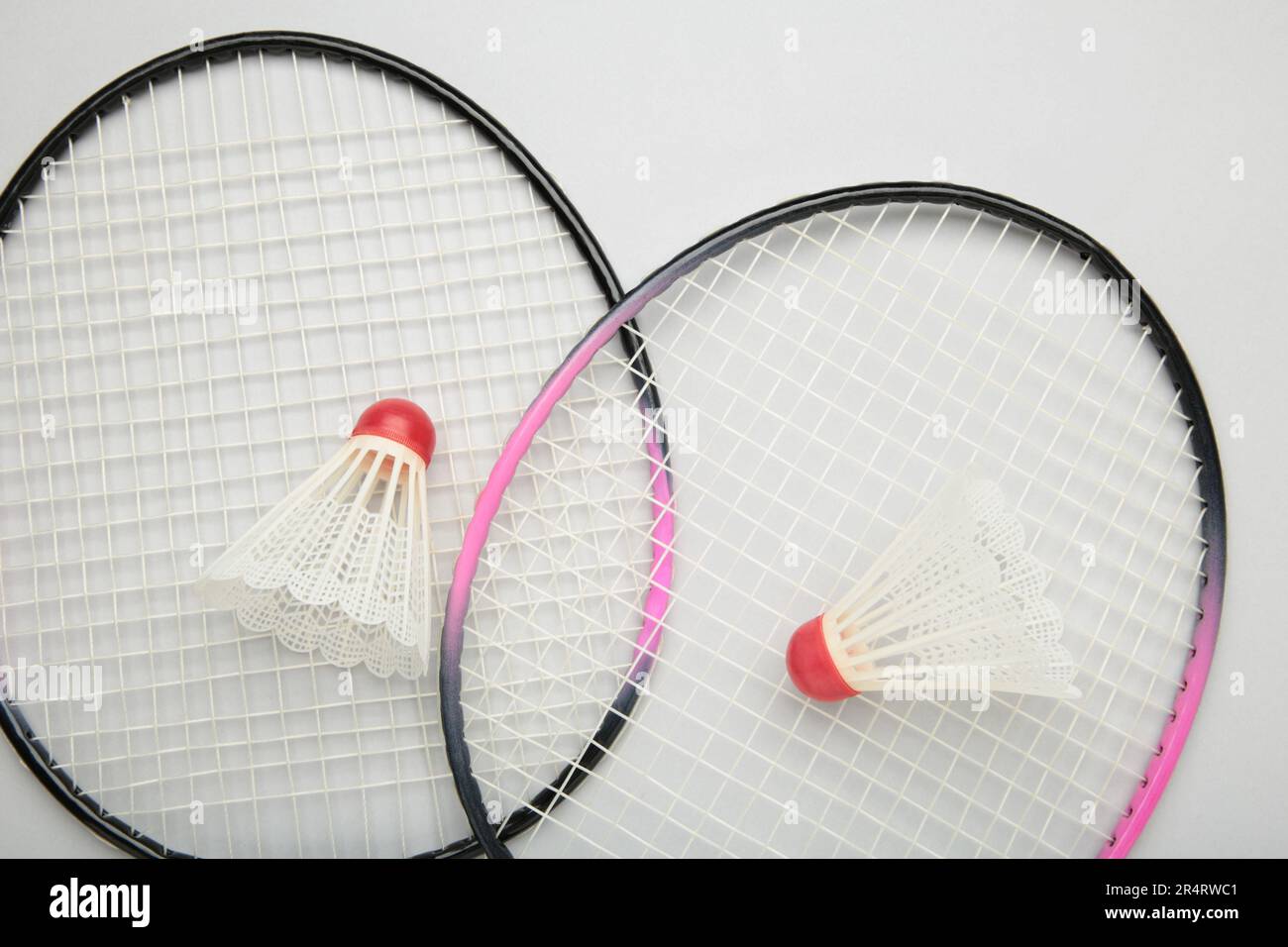 Shuttlecocks and badminton rackets on grey background. Top view. Stock Photo