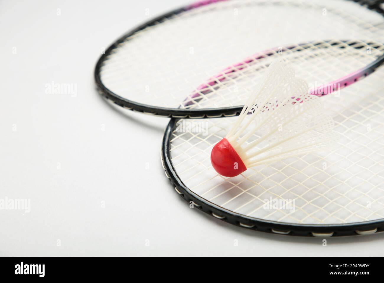 Shuttlecocks and badminton rackets on grey background. Top view. Stock Photo