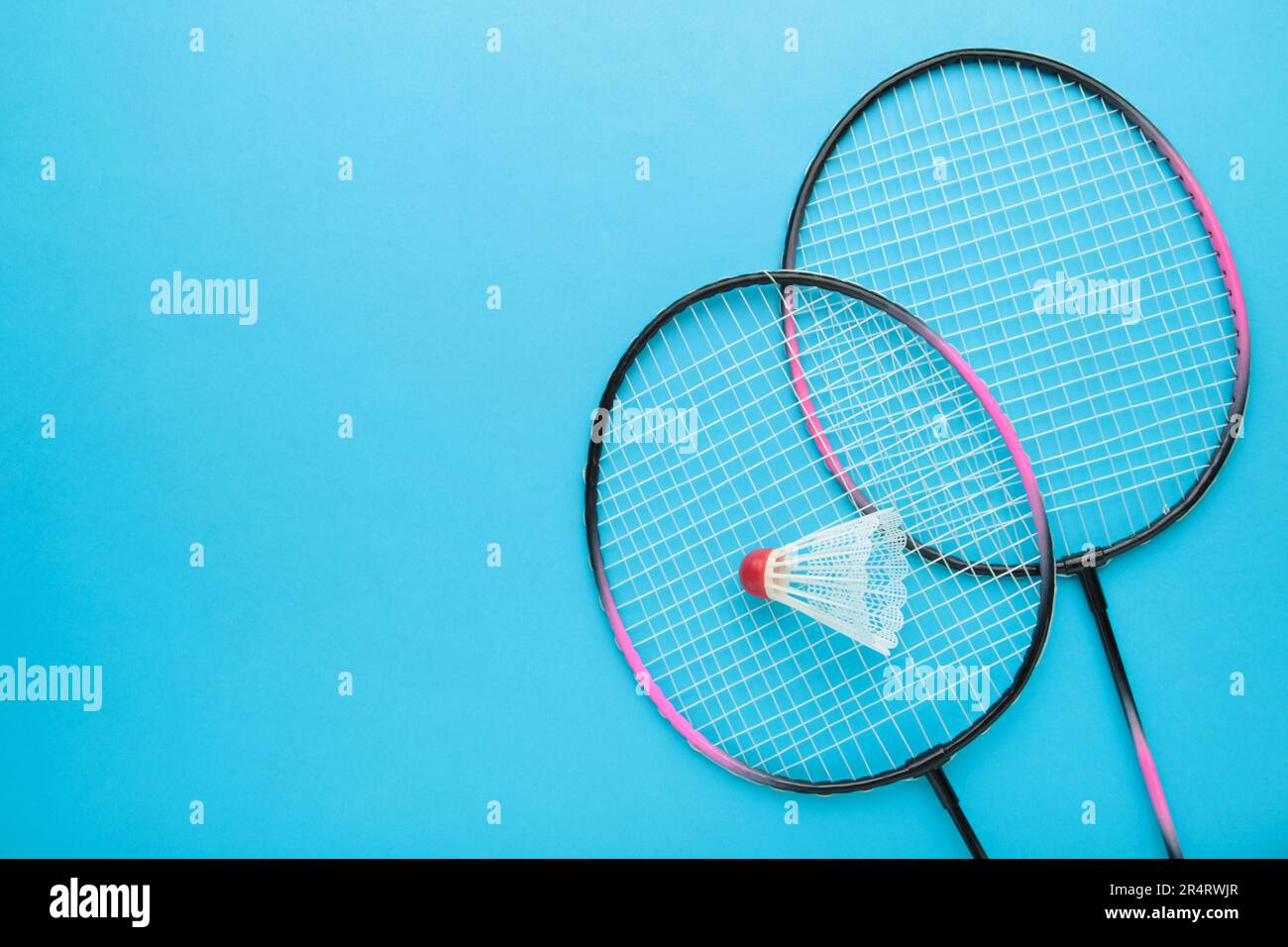 Shuttlecocks and badminton racket on blue background. Top view. Stock Photo
