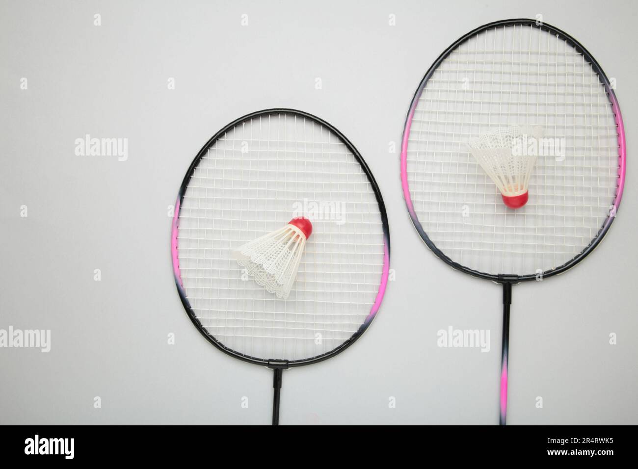 Shuttlecocks and badminton rackets on grey background. Top view. Stock Photo