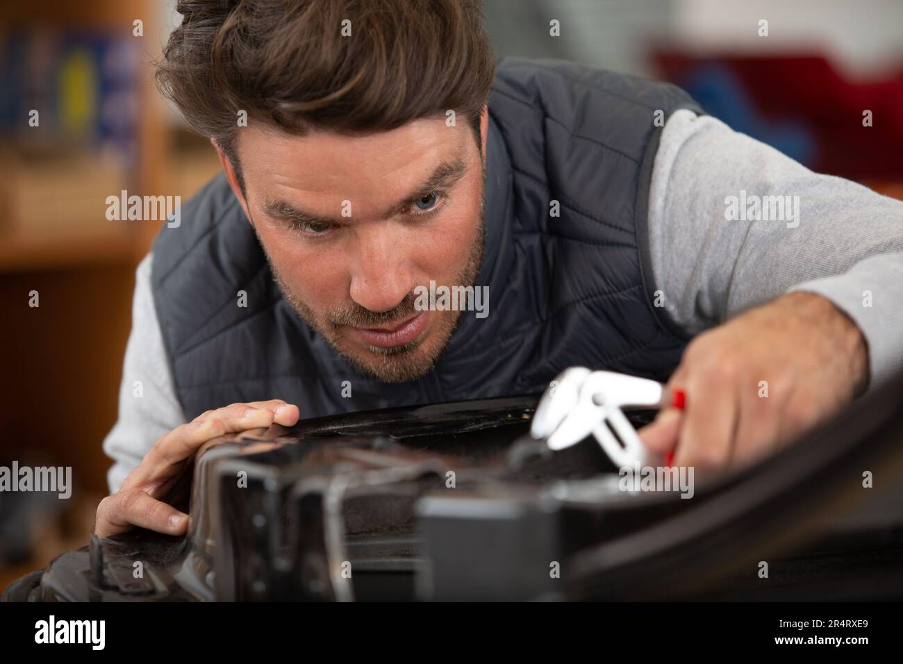 young handsome coachbuilder at work in garage Stock Photo