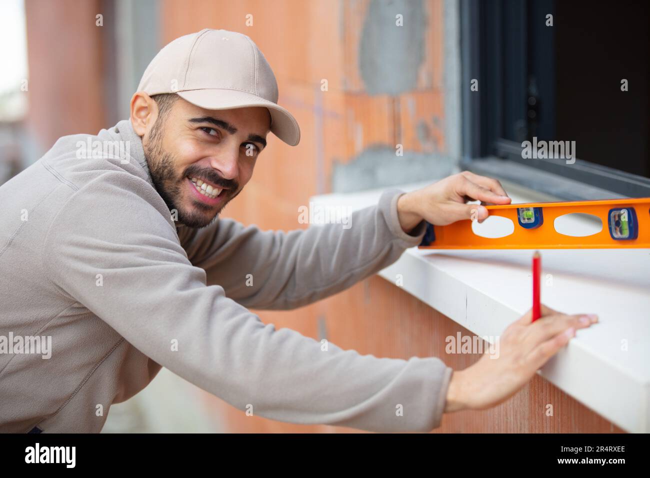 bricklayer checking wall level with spirit level Stock Photo