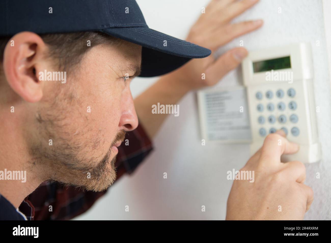hvac technician fixing a thermostat Stock Photo